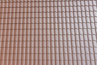 Evin çatısında kahverengi metal fayans var. Oluklu metal çatı