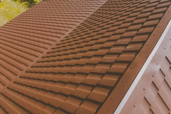 Braune Metallziegel auf dem Dach des Hauses. Wellblechdach — Stockfoto