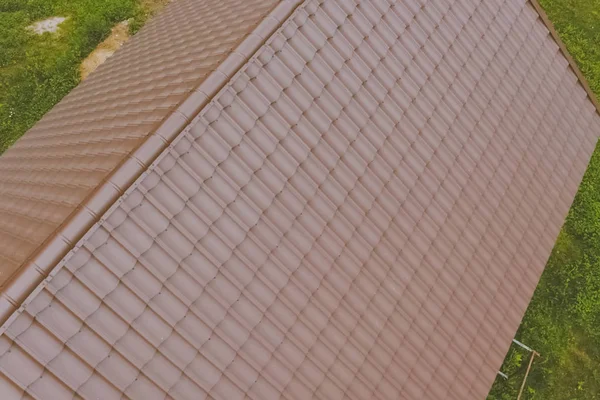 Baldosas de metal marrón en el techo de la casa. Techo de metal corrugado —  Fotos de Stock