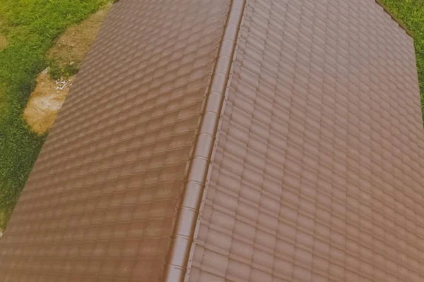Baldosas de metal marrón en el techo de la casa. Techo de metal corrugado —  Fotos de Stock