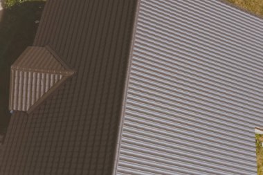 Evin çatısında kahverengi metal fayans var. Oluklu metal çatı