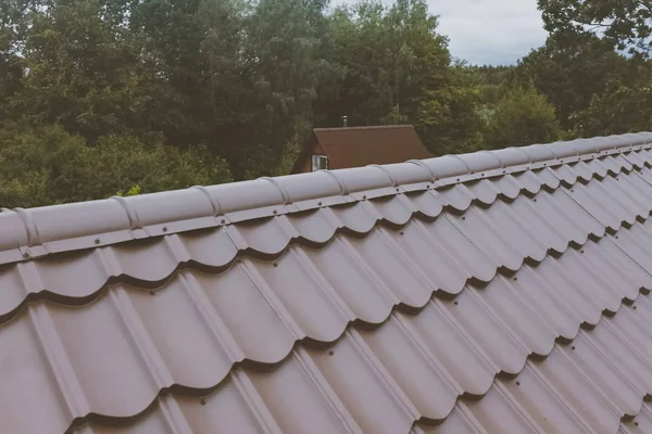 Evin çatısında kahverengi metal fayans var. Oluklu metal çatı — Stok fotoğraf