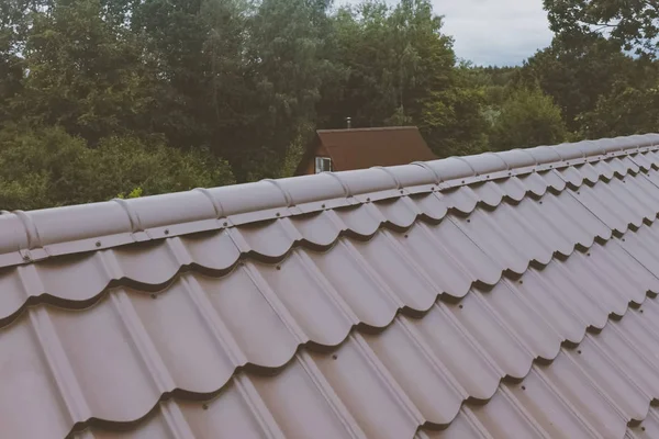 Brown metal tile on the roof of the house. Corrugated metal roof — Stock Photo, Image