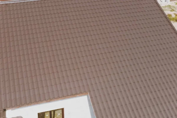 Коричневая металлическая плитка на крыше дома. Гофрированная металлическая крыша — стоковое фото