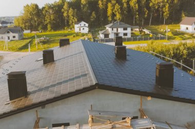 Metalden yapılmış endüstriyel bir binanın koyu gri çatısı. Corrugat