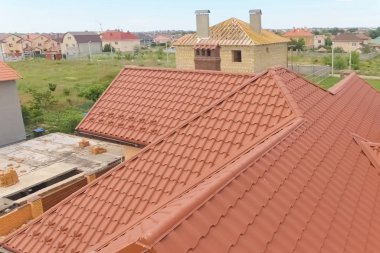 Turuncu metalden yapılmış yeni çatılı bir ev. Yukarıdan bak. Cor