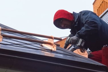 İşçi evin çatısını kuruyor. Kurulum