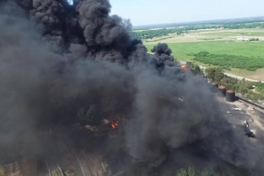 Yağ depolama yangını. Tank çiftliği yanıyor, siyah duman çıkıyor.