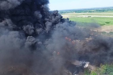 Yağ depolama yangını. Tank çiftliği yanıyor, siyah duman çıkıyor.