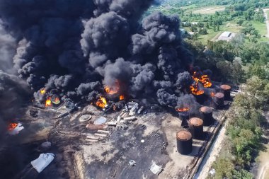 Yağ depolama yangını. Tank çiftliği yanıyor, siyah duman çıkıyor.