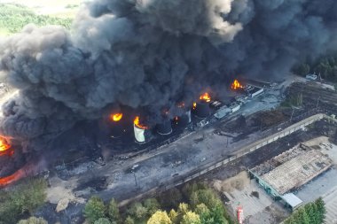 Yağ depolama yangını. Tank çiftliği yanıyor, siyah duman çıkıyor.