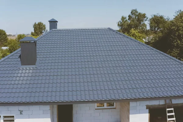 Grijs-blauwe metalen dakpannen op het dak van het huis. gegolfd — Stockfoto