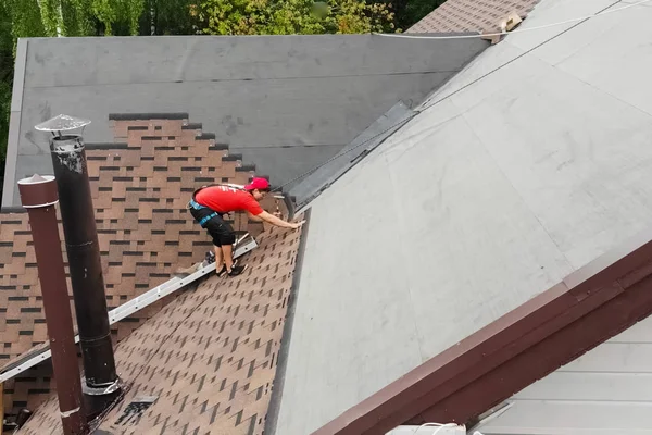 A munkás szereli fel a ház tetejét. Létesítmény — Stock Fotó
