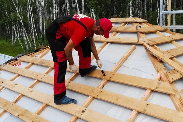 Arbetaren gör installationen av taket på huset. Anläggning — Stockfoto