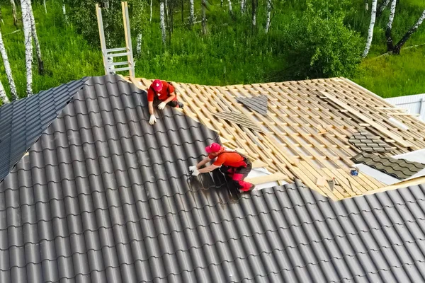 A munkás szereli fel a ház tetejét. Létesítmény — Stock Fotó
