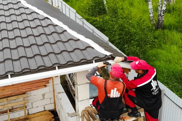 Arbetaren gör installationen av taket på huset. Anläggning — Stockfoto