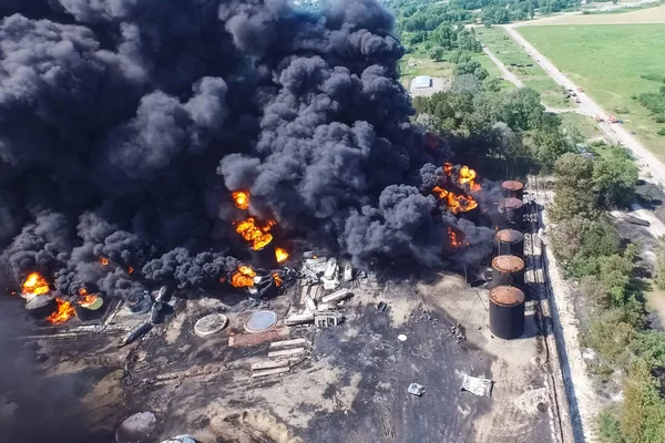 Fuego de almacenamiento de aceite. La granja de tanques está ardiendo, humo negro es combu Fotos de stock libres de derechos