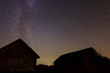 Köydeki ahşap evlerin üzerinde yıldızlı gökyüzü. Yıldızlı gökyüzü gece gökyüzündeki yıldızların ve Samanyolu 'nun arkaplan resmi.