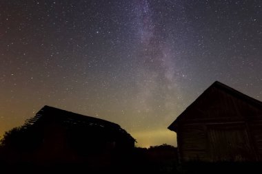 Köydeki ahşap evlerin üzerinde yıldızlı gökyüzü. Yıldızlı gökyüzü gece gökyüzündeki yıldızların ve Samanyolu 'nun arkaplan resmi.