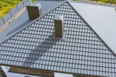 Gri metal çatılı ev. Oluklu metal çatı ve metal ro