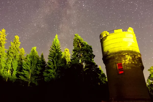 Cielo estrellado sobre el bosque y la torre de agua. Timelapse estrellado — Foto de Stock