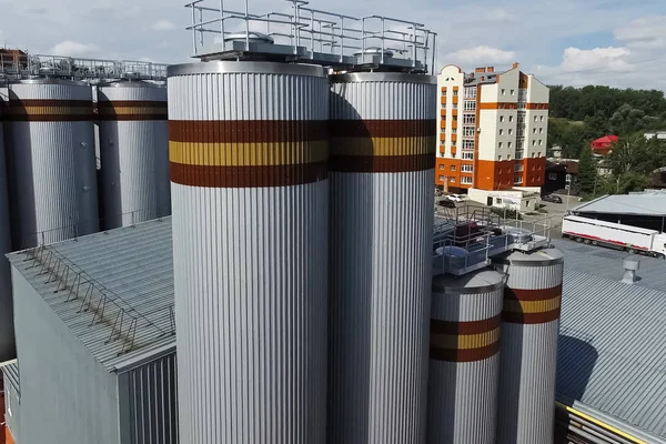 Brewery, barrels and cisterns of factory outside view.