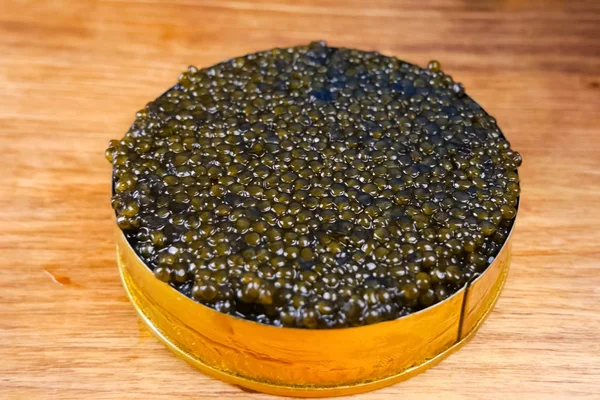Black caviar in cardboard box. Spooning black caviar. — Stock Image Black caviar in cardboard box. Spooning black caviar. Stock Image