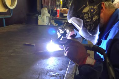 Kaynakçı metal parçaları bir Workbench üzerinde kaynak.
