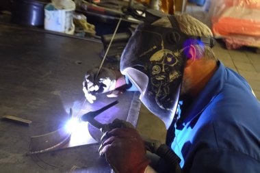 Kaynakçı metal parçaları bir Workbench üzerinde kaynak.