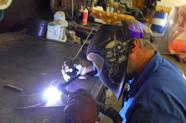 Kaynakçı metal parçaları bir Workbench üzerinde kaynak.