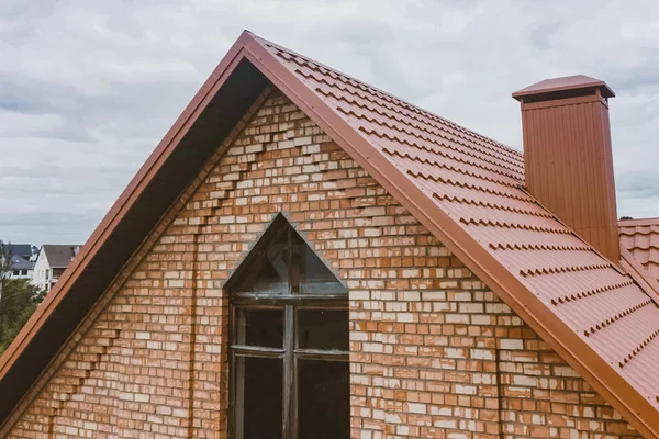 Hermosa casa de ladrillo rosa y techo naranja. Corrugado met — Foto de Stock