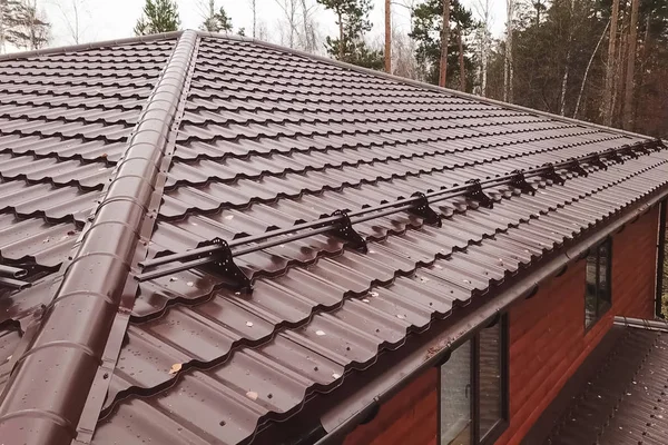 Casa com um telhado de metal marrom. Telhado de metal ondulado e metal ro — Fotografia de Stock