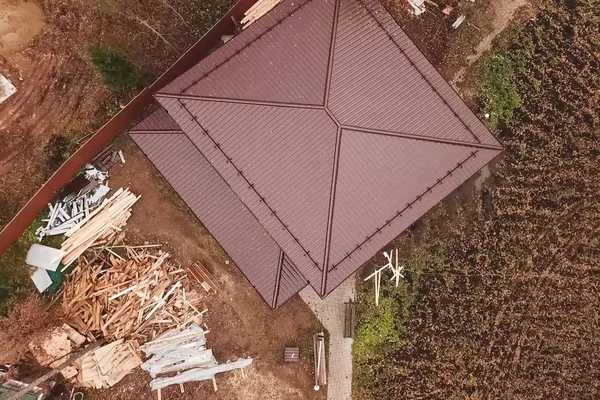 Casa con un tetto in metallo marrone. Tetto in metallo ondulato e metallo ro — Foto Stock