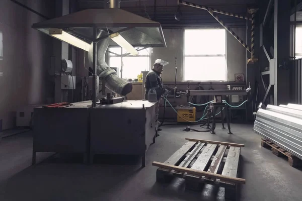 Worker works at a climatic equipment factory.