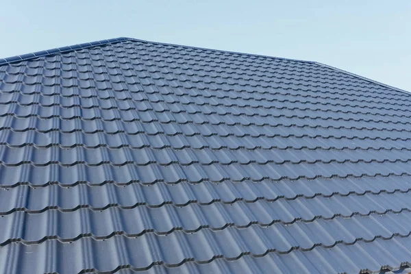 Takläggning av korrugerad metall och plåttak. Modernt tak tillverkat av met Stockbild