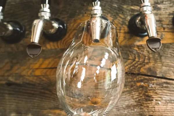 Bier in een glas gieten uit de kraan aan de bar. Bierbotteling. — Stockfoto