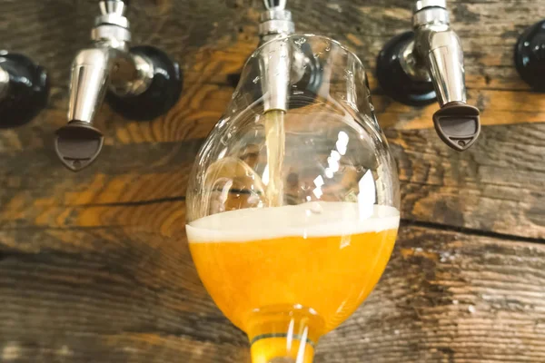 Bier aus dem Zapfhahn an der Theke in ein Glas gießen. Bierabfüllung. — Stockfoto