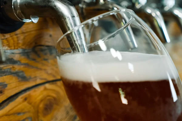 Verter cerveza en un vaso del grifo del bar. Embotellado de cerveza . —  Fotos de Stock