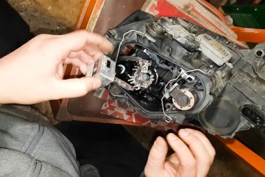 Ksenon lambası bir elektrikçinin elinde. Ksenon lambaları değiştiriliyor.