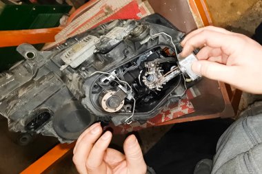 Ksenon lambası bir elektrikçinin elinde. Ksenon lambaları değiştiriliyor.