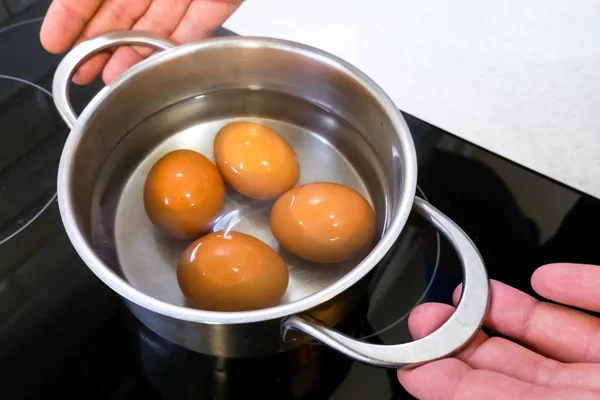 Gotowane jajka na patelni są usuwane z pieca. — Zdjęcie stockowe