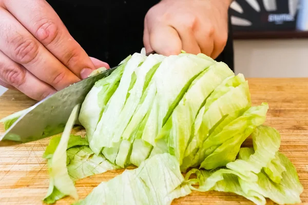 Snijd rauwe kool op een snijplank met mes. kooksneden kool — Stockfoto