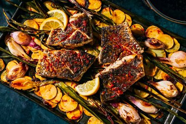 Kızarmış balık fileto, patates kızartması ve soğanlı.