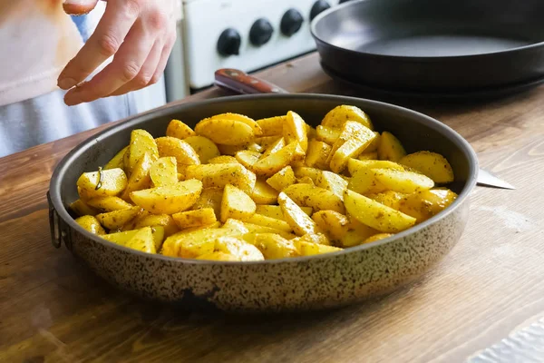 Patatas fritas con especias en sartén. Especias en la patata . Fotos de stock libres de derechos