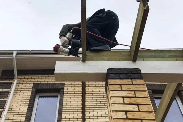 El trabajador trabaja con un martillo neumático, martillos clavos en el Fotos de stock