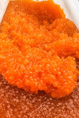 Plastik kabın içinde kırmızı havyar. Somon havyarı, diyet yemek..