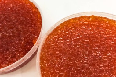 Plastik kabın içinde kırmızı havyar. Somon havyarı, diyet yemek..