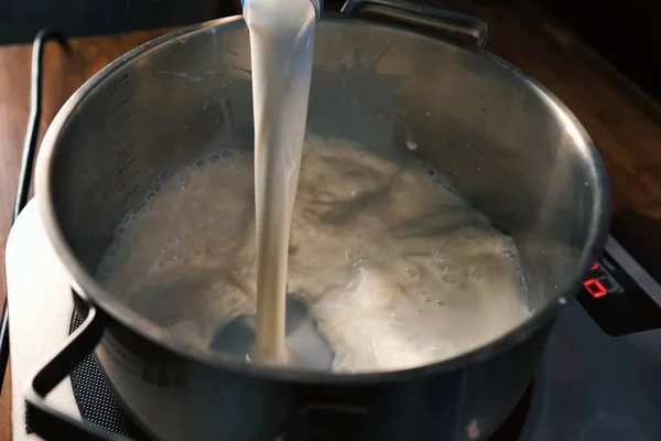 Выливание молока в кастрюлю на весах . — стоковое фото