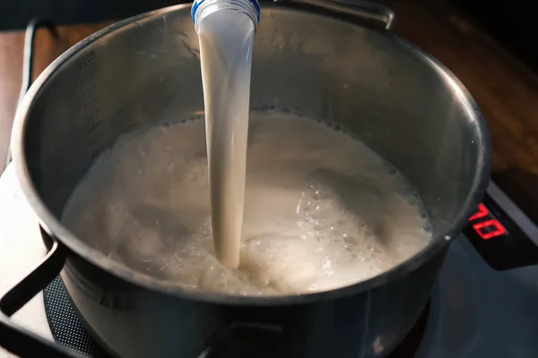 Pouring milk into the pan on scales.