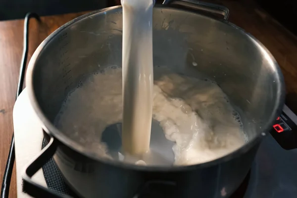 Наливаємо молоко в сковороду на луски . — стокове фото